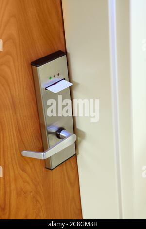 A modern key card door lock on a hotel room door, with a key card inserted. Stock Photo