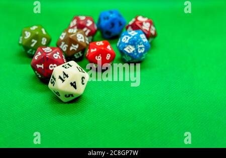 Several colored dice of role-playing on top of green background Stock Photo