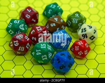 Yellow role-playing board with several colored dice on top in a pentagonal shape Stock Photo