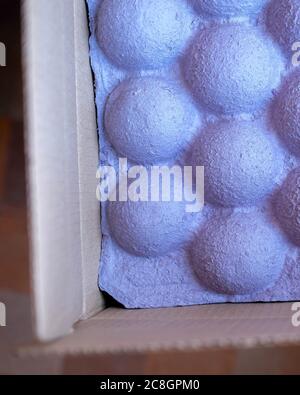 Tight packing for fixing goods in a box. Vertical photo, blurred background. Purple hemispheres. Stock Photo