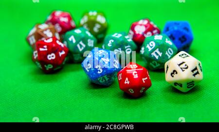 Several colored dice of role-playing on top of green background Stock Photo