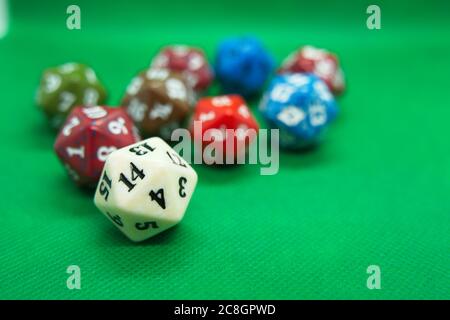 Several colored dice of role-playing on top of green background Stock Photo