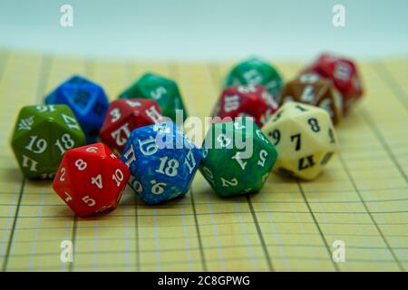 Yellow role-playing board with several colored dice on top in a pentagonal shape Stock Photo