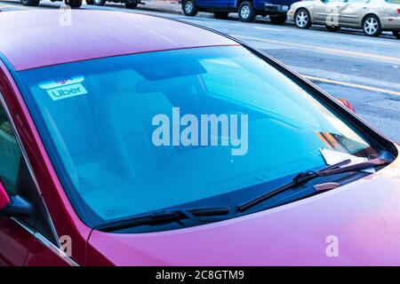 Lyft and Uber emblem stickers under car windshield. Parking ticket under windscreen wiper - San Francisco, CA, USA - 2020 Stock Photo