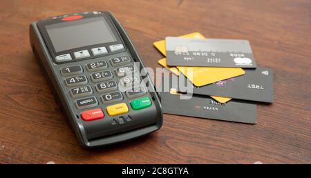 POS terminal and credit cards on wooden background, Terminal cash register machine for contactless payment. Banking equipment, Consumerism, shopping c Stock Photo