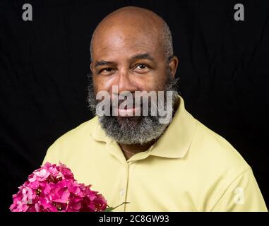 man smiling holding a bouquet of hydrangea and yellow flowers looking ...