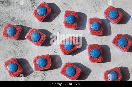 Red and blue tablets for dishwashing machine. Detergents for home hygiene Stock Photo