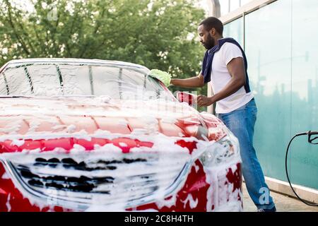 Red compact SUV car with sport and modern design washing with soap. Car  covered with white foam. Car care service business concept. Car wash with  foam Stock Photo - Alamy