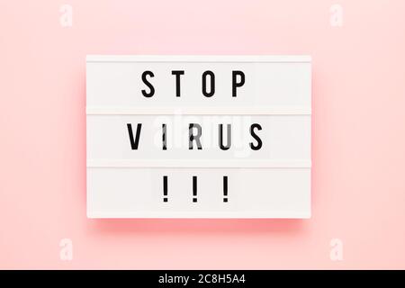 STOP VIRUS is written in lightbox on pink background. Healthcare and medical concept. Top view, copy space. Quarantine concept. Stock Photo