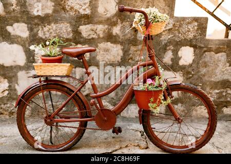 Stylish bike with pots for flowers against the background of brick blocks. Stock Photo