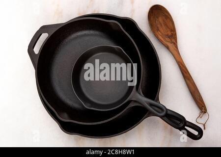 Clean Cast Iron Skillet with Wooden Spoon and Sprigs of Rosemary Stock Photo