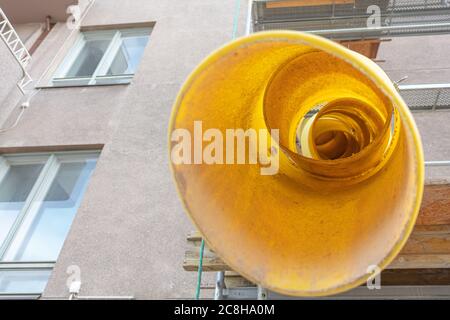 Yellow telescope rubble chute. Plastic garbage chute fixed on facade. Repair in apartment, office of old historical building. Disposal of construction waste from height. High quality photo Stock Photo