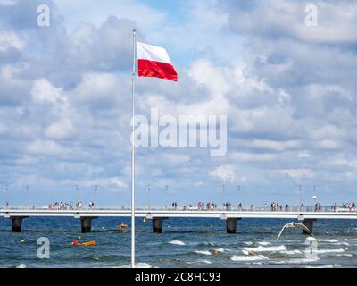 on a flagpole the red and white flag of Poland is waving Stock Photo