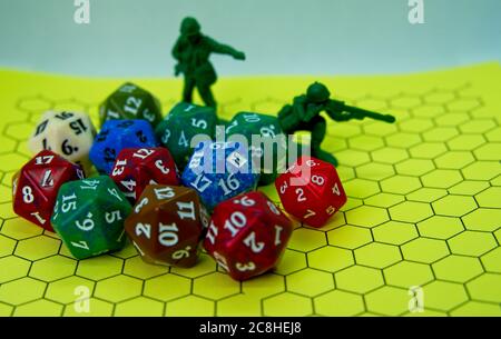Role-playing board with pentagonal-shaped several colored dice and plastic figures on top of the board Stock Photo