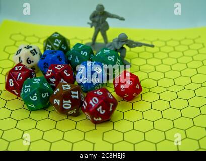 Role-playing board with pentagonal-shaped several colored dice and plastic figures on top of the board Stock Photo