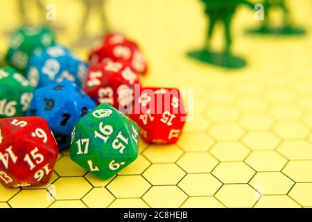 Role-playing board with pentagonal-shaped several colored dice and plastic figures on top of the board Stock Photo