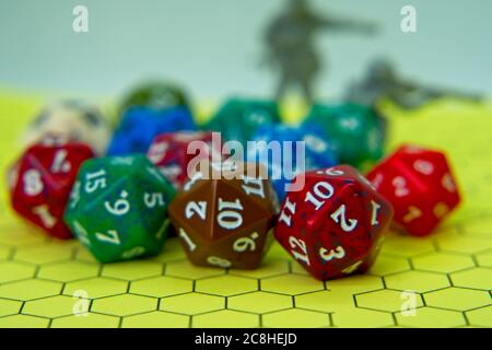 Role-playing board with pentagonal-shaped several colored dice and plastic figures on top of the board Stock Photo