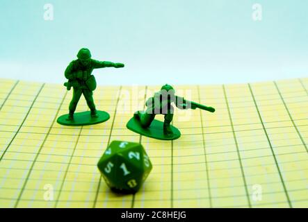 Role-playing board with pentagonal-shaped one dice and plastic figures on top of the board Stock Photo