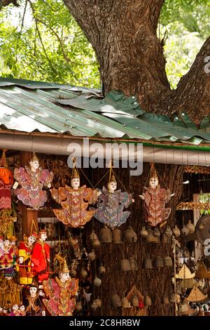 Puppets dressed in traditional Burmese costumes are hanging to be sold to tourists in front of the souvenir shop. Stock Photo
