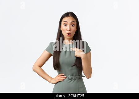 Small business owners, women entrepreneurs concept. Surprised and shocked asian woman in dress asking question and pointing at herself, being chosen Stock Photo