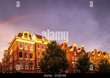 Rainbow over row houses in Amsterdam Stock Photo