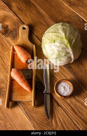 Wooden cabbage grater, piece of cabbage, carrot, assorted pepper and  himalayan salt on cutting board and on blue wooden table. Flat lay with  cabbage f Stock Photo - Alamy