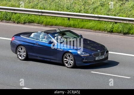 2011 blue BMW 640I SE Turbo Auto Cabrio; Vehicular traffic moving vehicles, cars driving vehicle on UK roads, motors, motoring on the M6 motorway highway network. Stock Photo