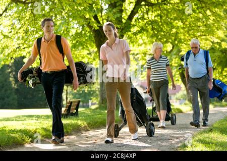 A group of golfers walking to the next tee Stock Photo