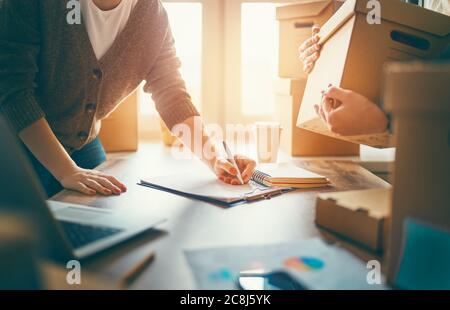 Two people are working together at warehouse for online seller. Concept of small business. Stock Photo