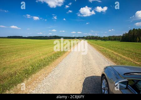 Long straight dirt road through farmland at Summer at countryside , Finland Stock Photo