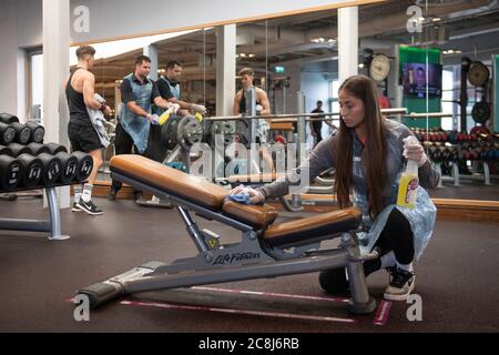 A member of staff cleans down gym equipment at David Lloyd in