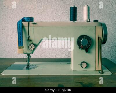 Old vinatge romanian sewing machine with sewing thread. Tailoring meter on a sewing machine. Stock Photo