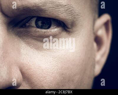 half face detailed portrait of a man looking at the camera. Stock Photo