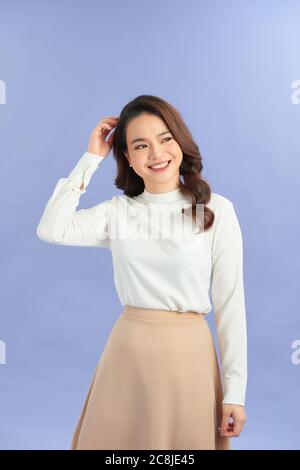 Portrait of a beautiful young woman casually dressed standing isolated over purple background Stock Photo