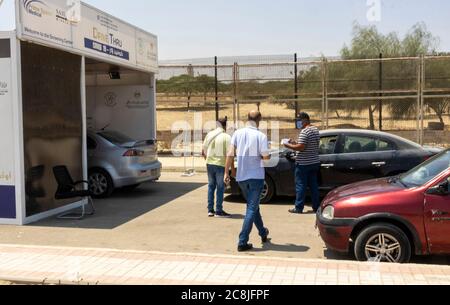 Cairo, Egypt. 25th July, 2020. Cashier taking money from driver for Covid 19 testing at drive through unit of Prime Speed medical Credit: B.O'Kane/Alamy Live News Stock Photo