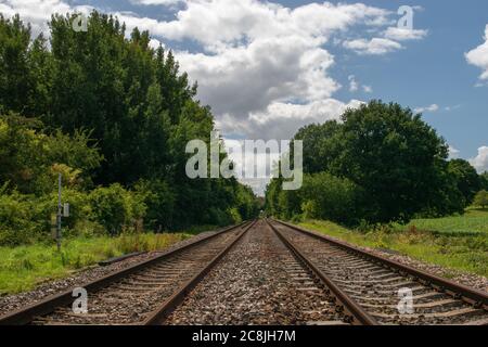 Perspective view up a twin track railway from ground level in the English countryside Stock Photo