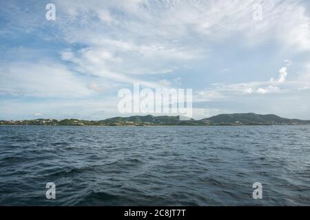 View of the rolling island landscape with the Caribbean Sea waters under a cloudy sky in St. Croix in the USVI Stock Photo