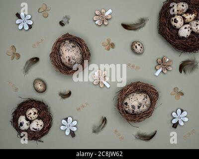 Natural quail eggs in the nests, feathers and easter decoration from natural materials. Overhead view. Easter zero waste concept. Stock Photo
