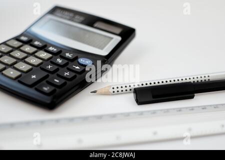 Close-up view accounting calculator white office desk table near pen, pencil, measuring scale and other office supplies Stock Photo
