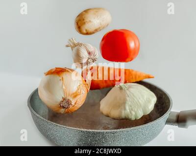 Vegetables levitating over a frying pan for a vegetable stew. Cooking concept. Stock Photo