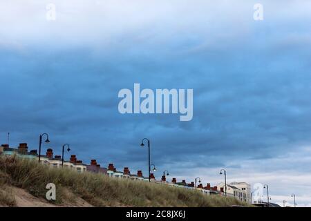 Dark patch of cloud within white clouds above a seaside town (Pwllheli, North Wales) Stock Photo