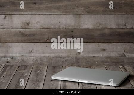 Mock up of blank laptop on the desk. Personal laptop computer on wood table over brick wall background. Stock Photo