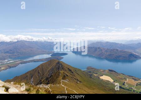 The view from the summit of Roys Peak over Lake Wanaka and the mountains of the Southern Alps as clouds roll over them. Stock Photo