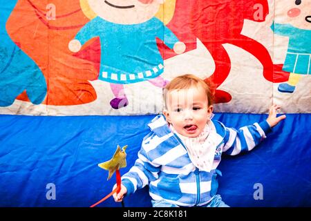 Girl with coat next to an inflatable castle, alone and sad. Stock Photo