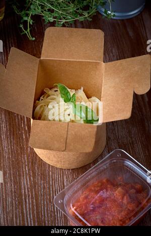 Pasta fettuccine with tomato sauce on a carton box take away Stock Photo