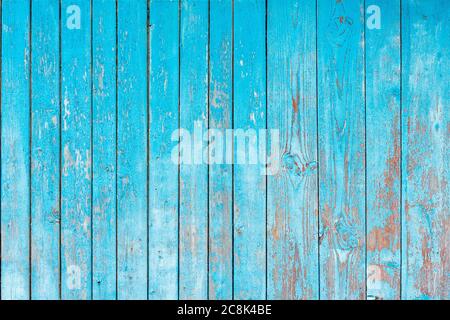 old shabby blue wooden fence. blue background Stock Photo
