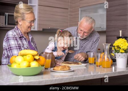 Little girl making pancakes with her grandparents Stock Photo