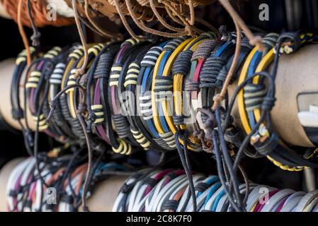 Lots of bracelets made with colorful ropes arranges in a row on a cylinder Stock Photo
