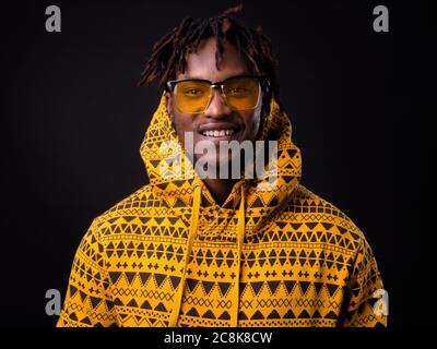 Young African man with dreadlocks against black background Stock Photo