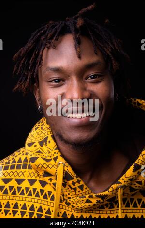 Young African man with dreadlocks against black background Stock Photo